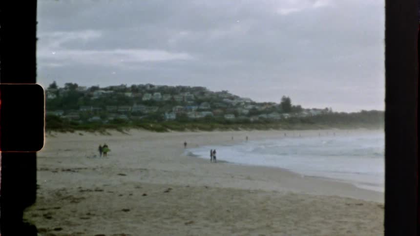 People stand around on a beach