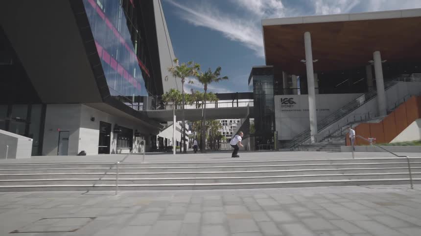 Man moves along the ground using roller skates and jumps over the wall in the city