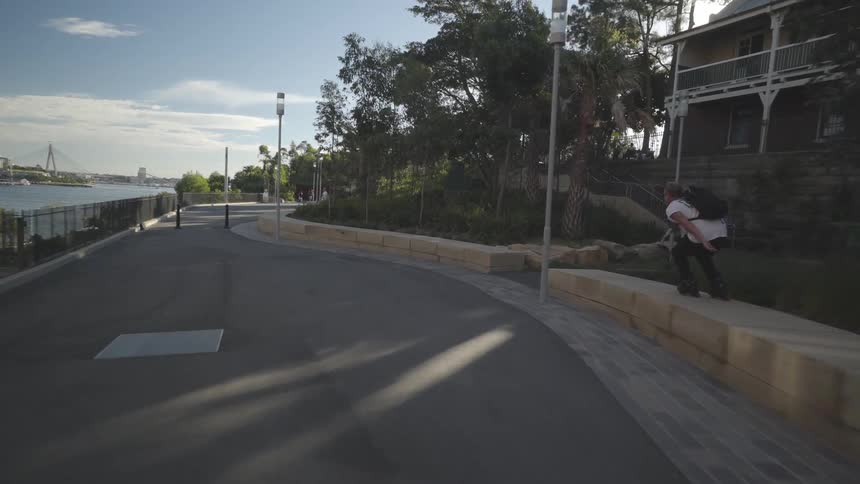A white male skateboards down a city footpath