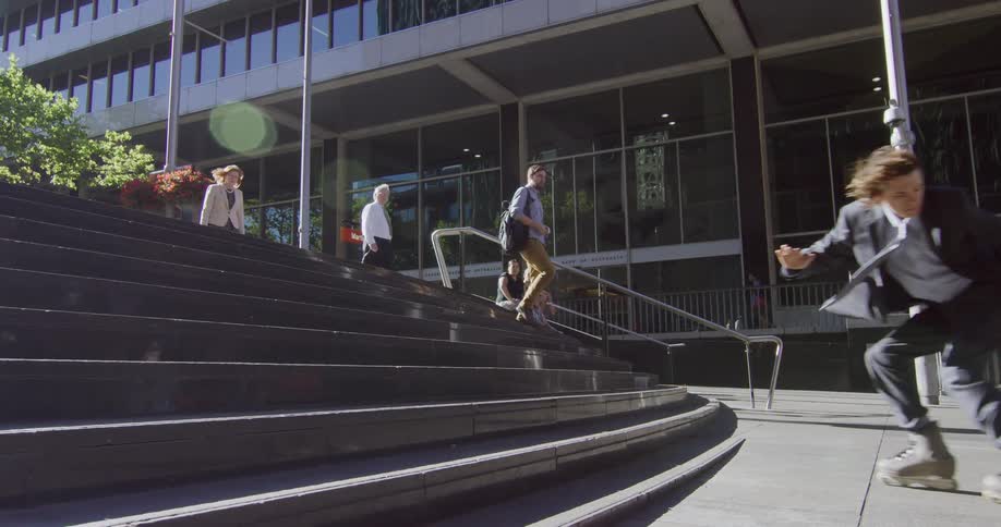 A person rollerblading down stairs while others walk down it
