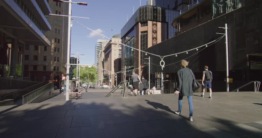 People walking down a pathway between buildings