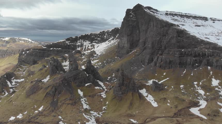 A mountain covered with some snow is displayed
