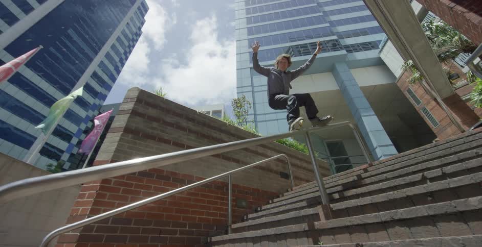 A teenager roller skates down a stair railing