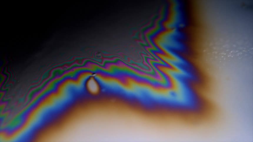 A liquid moves and gives off psychedelic colors