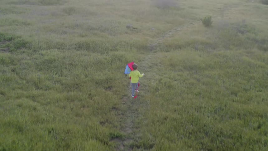 A child runs while carrying a kite
