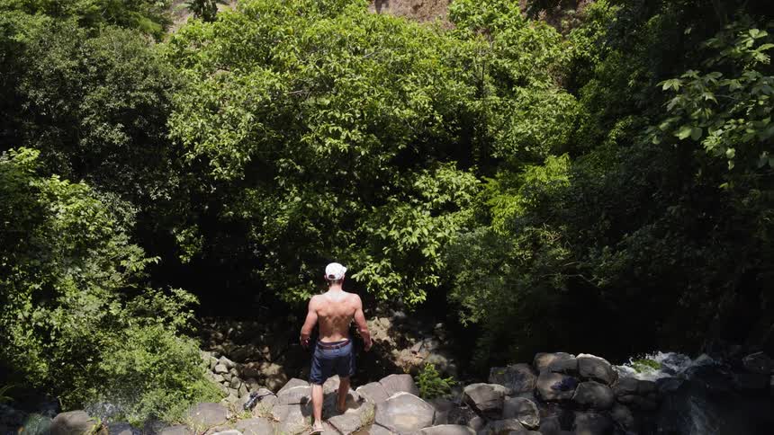 Man walks forward to stand at edge of cliff