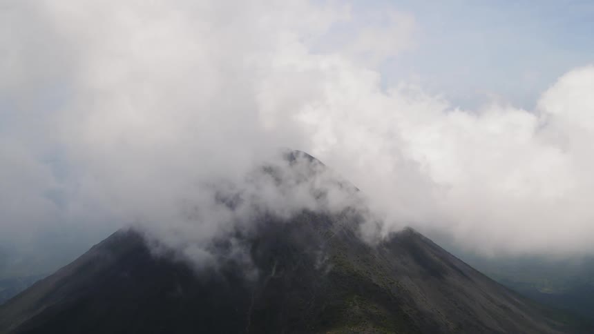 Clouds cover the peak of a volcano