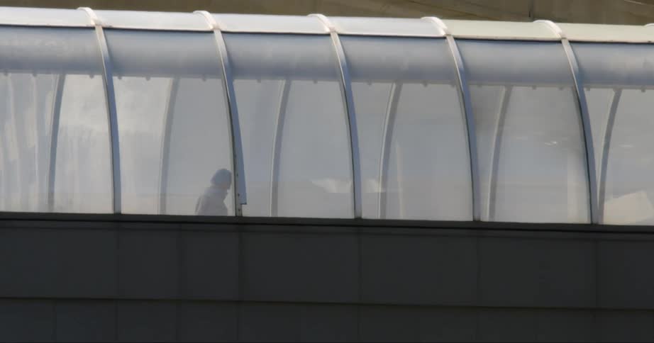 A person walks through a pedestrian bridge