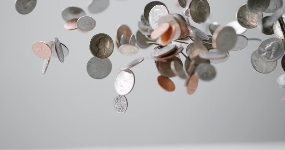 Coins being tossed in the air and falling in slow motion