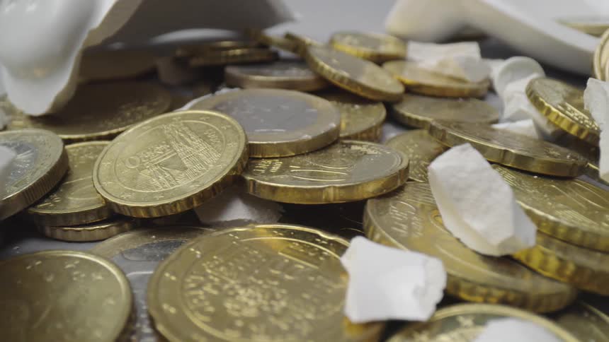 The piggy bank lays broken with coins