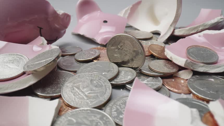 A broken piggy bank and the coins that spilled out of it