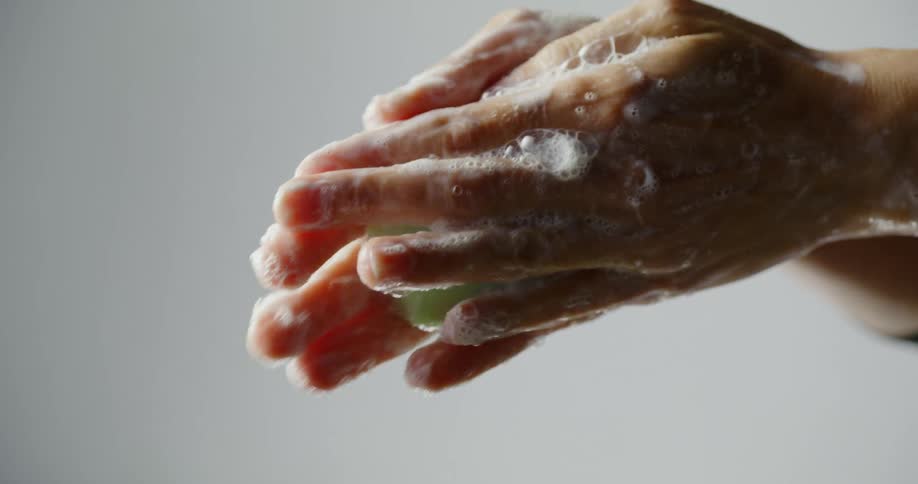 A person washes their hands with soap