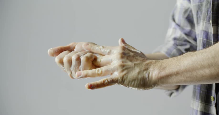 A man washes his hands with soap