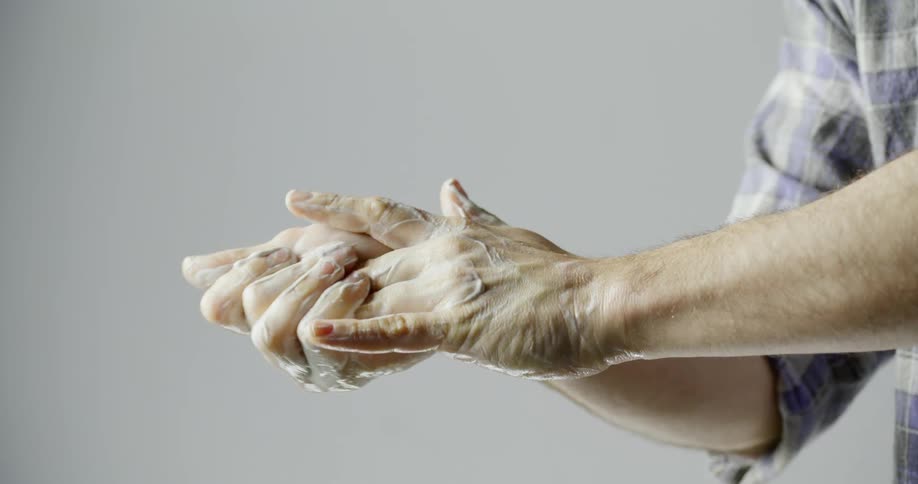A white man washes his hands with soap