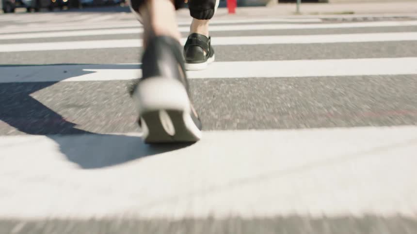 A person crossing a city street at a crosswalk