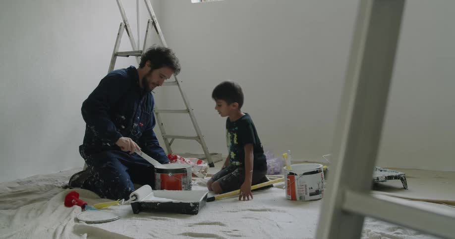 A father gets a paint can ready with his son