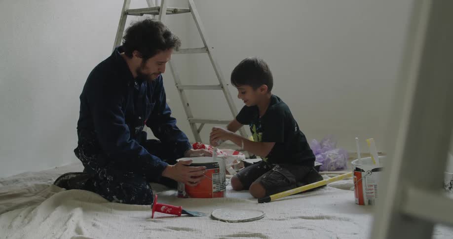 A man and child mix paint together