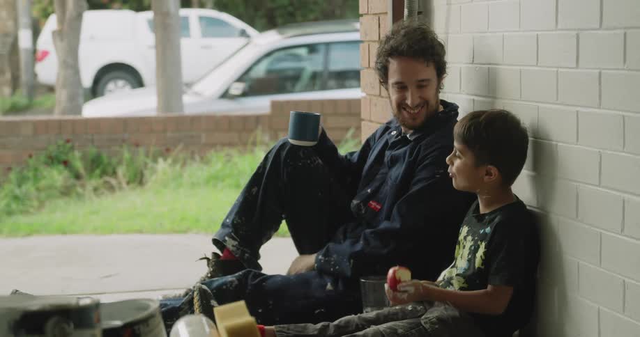 A father an son eating outside