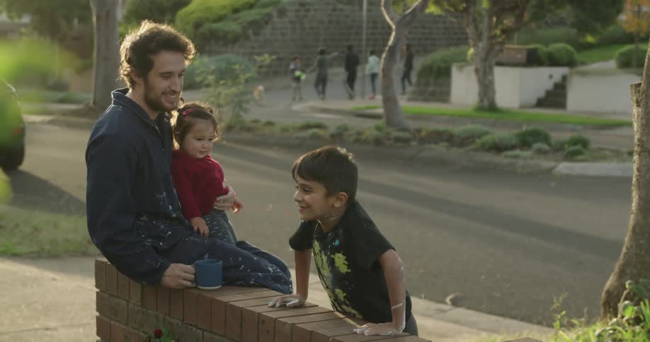 A family sit on the wall talking