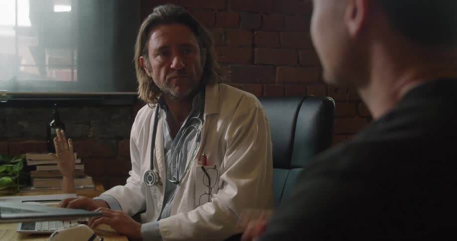 A doctor and a patient speak in a doctors office