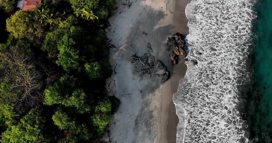 Aerial view of ocean waves crashing against secluded beach