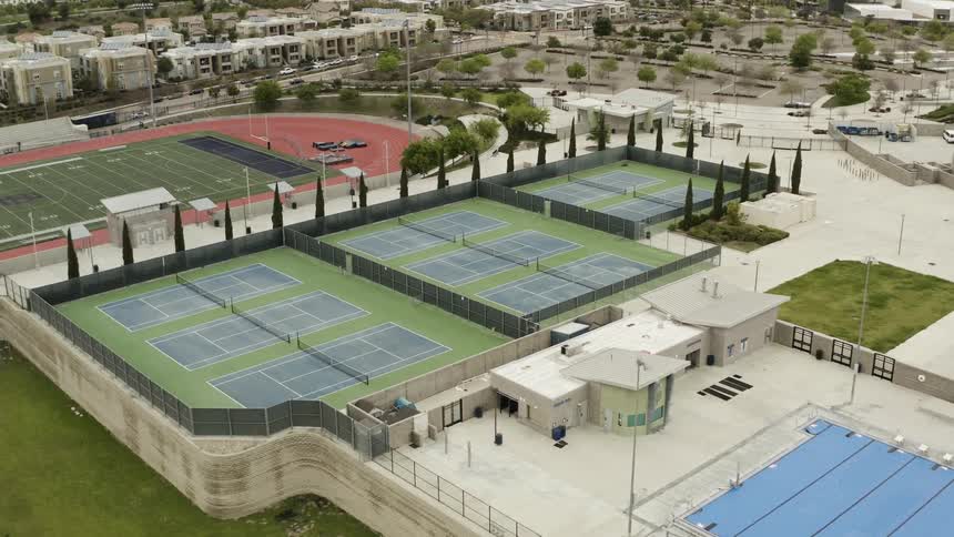 The tennis court and fields in the park are empty
