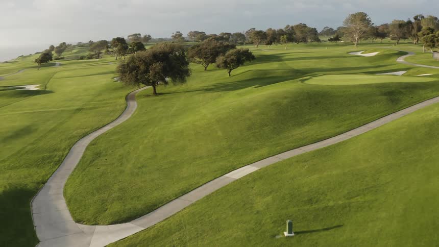 Empty golf course borders ocean on cloudy day