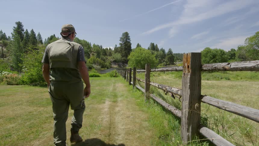 A fisherman walks in a rural area