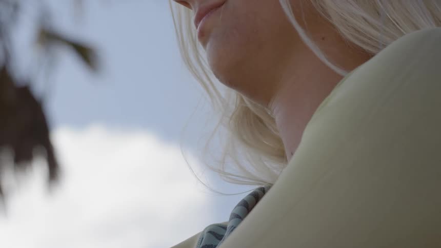 A blonde girl is putting on her jacket