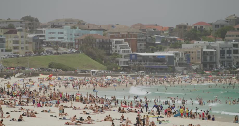 A crowded beach bordered in a city