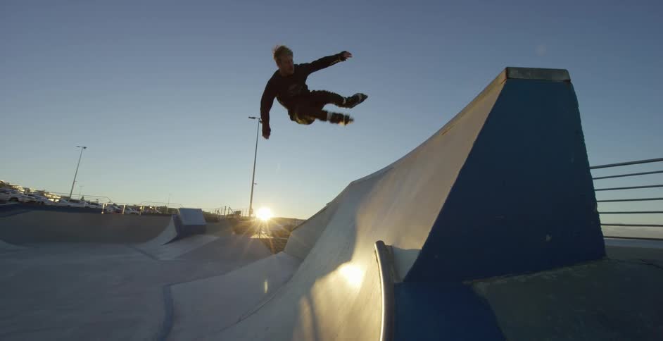 A man rollerblades in the skate park