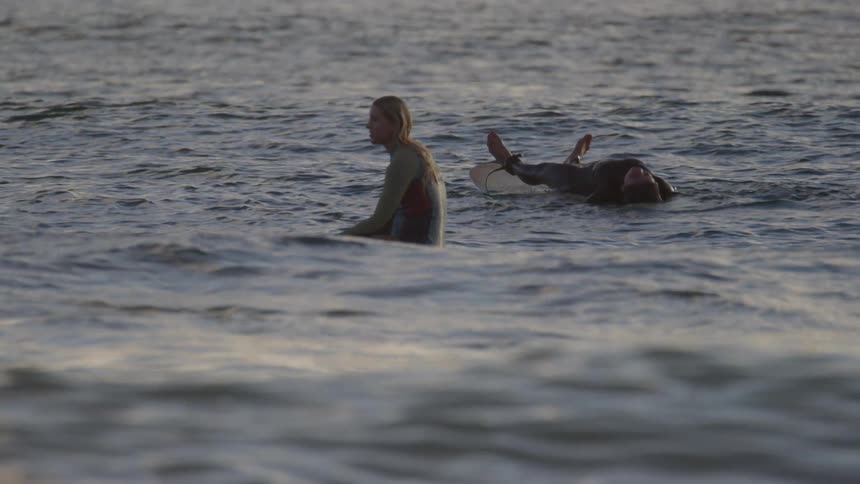 Two people floating on surfboards in ocean water