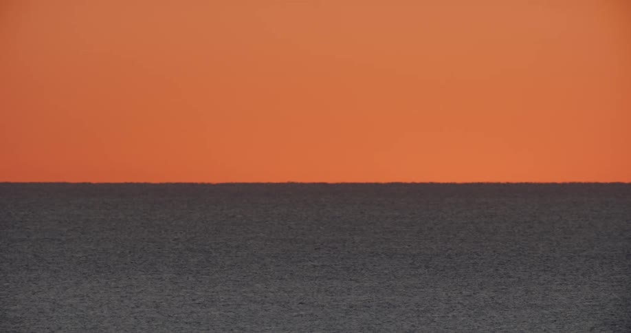 Aerial view of the tranquil ocean and red sky