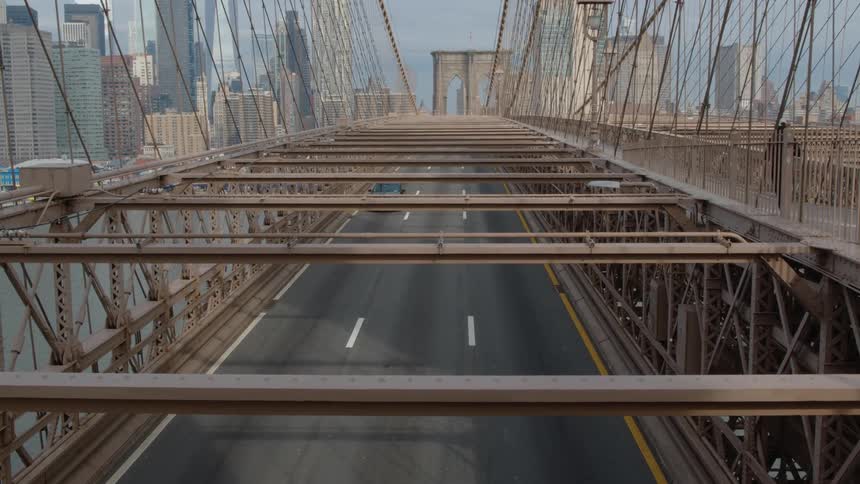 A person running on a bridge with vehicles with the city skyline in the background
