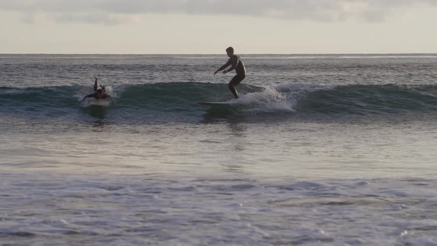 Surfers catching a wave