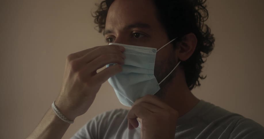 A man putting on a disposable mask