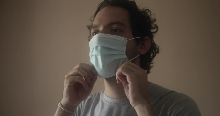 Man puts on face mask over beard and mustache then adjusts it