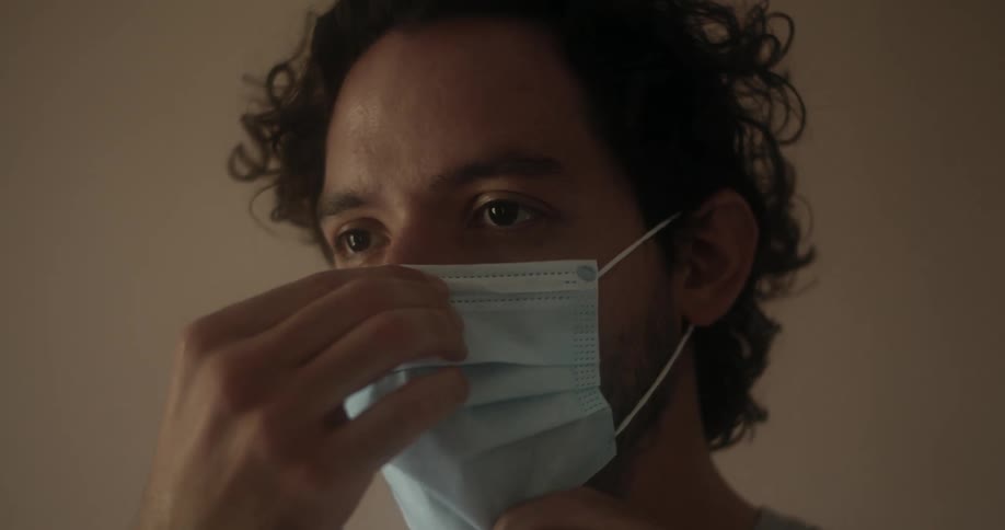 Man puts on and adjust face mask