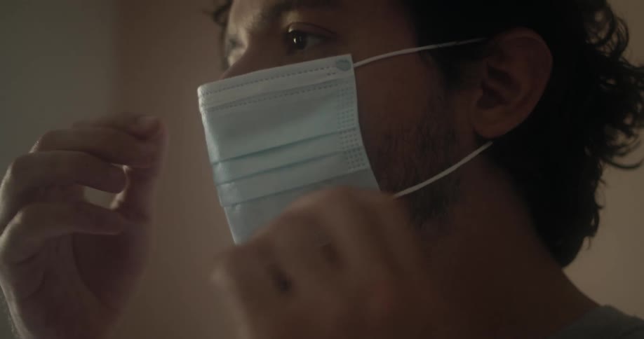 A man putting on a disposable face mask