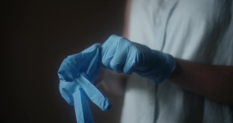 A woman puts gloves on