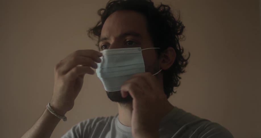 A man putting on a disposable face mask
