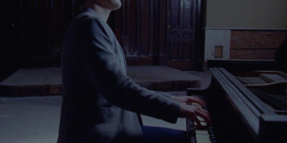 A young man plays the piano