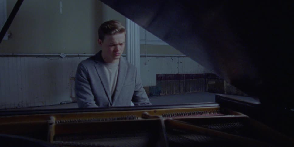A man sitting down playing the piano
