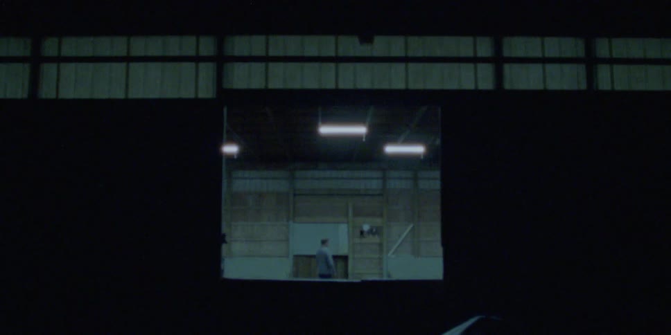 A man walks around a large warehouse