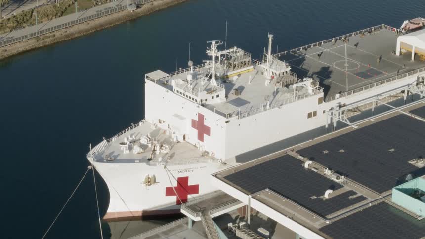 A hospital ship docked at building on a river
