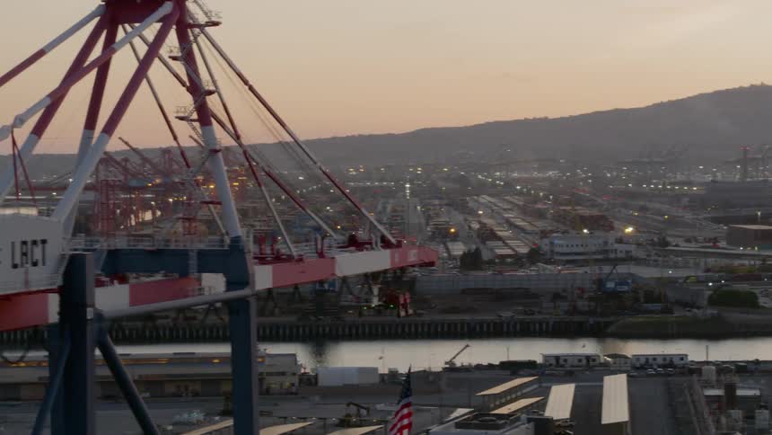 A crane sits high above a shipping yard along the water