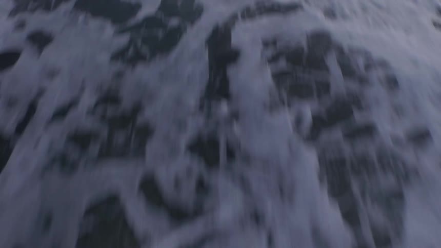 Close up of water moving and sand by the beach