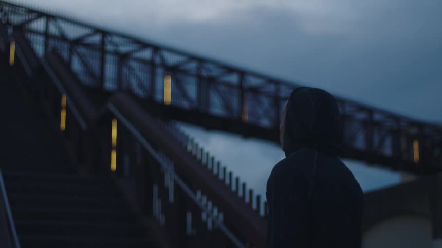 A man stands near the stairs