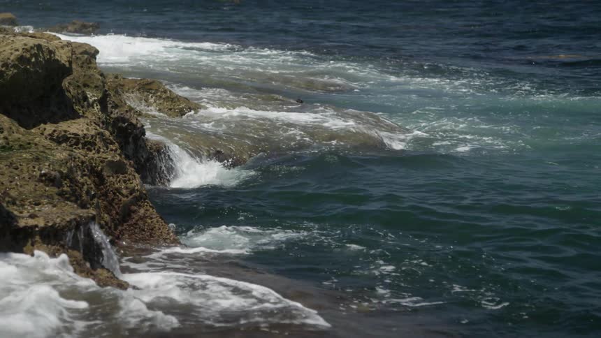 Waves crash against a rocky outcropping