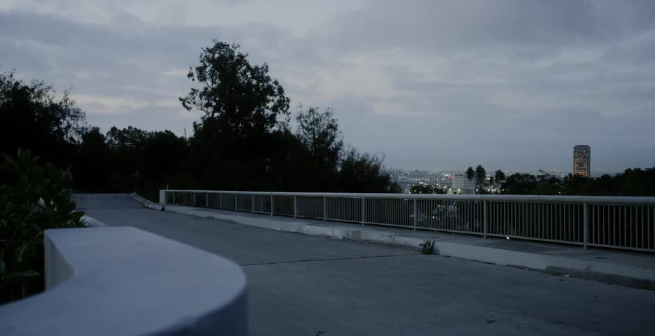 The city lights twinkle and glow seen from an empty overpass